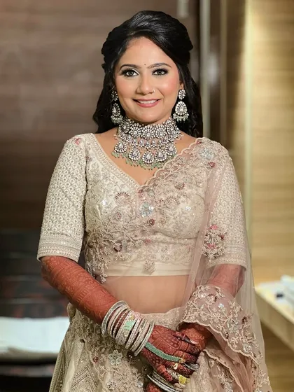 A full portrait of the bride, showcasing her elegant embellished lehenga.