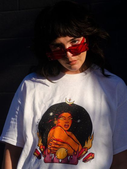 The 'Fire' element T-shirt, with a powerful figure surrounded by flames and crystals.