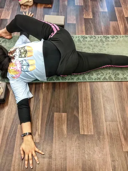 A student holds a deep twisting pose, demonstrating the strength and flexibility gained through our training.