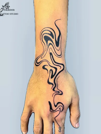 An abstract liquid flow design that moves from the wrist up the hand. This unique tattoo is all about movement and modern aesthetics.