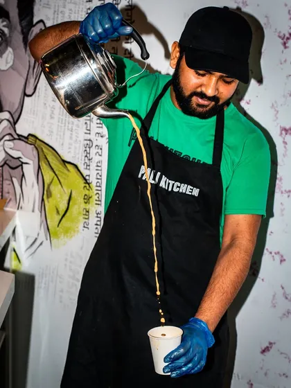 Theatrics can be part of the dining experience. This shot captures a chai-wala at Pali Kitchen doing a classic "pulled" tea pour, adding a sense of action and culture.