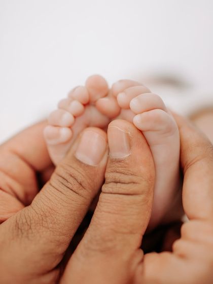 A parent's hands gently hold their baby's tiny feet, a photo that perfectly shows how small and precious they are.