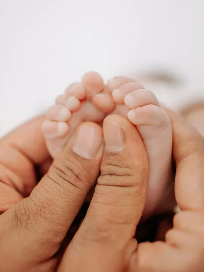 A parent's hands gently hold their baby's tiny feet, a photo that perfectly shows how small and precious they are.