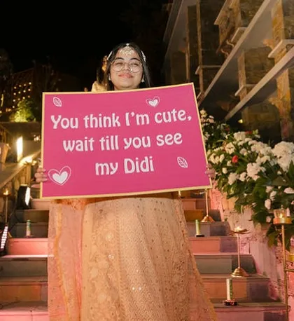 "Wait till you see my Didi." A cute placard held by the bride's sister, building anticipation for her entry.