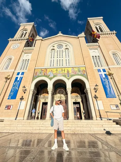 Posing in front of a grand cathedral in Athens. The low-angle shot emphasizes the scale of the architecture and my relaxed, tonal outfit.