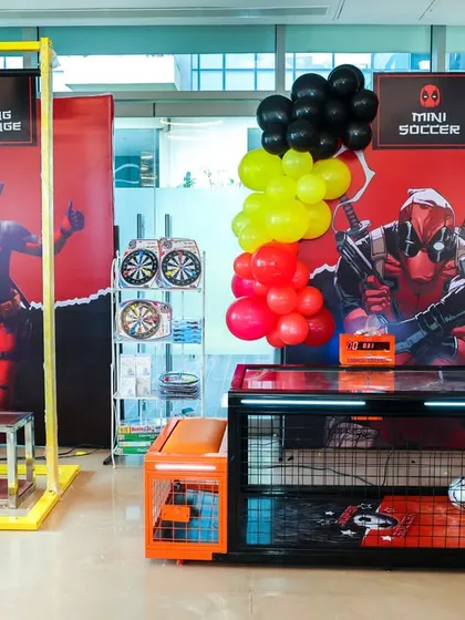 A wide shot of the game area, showing the mini soccer and hanging challenge setups, ready for guests.