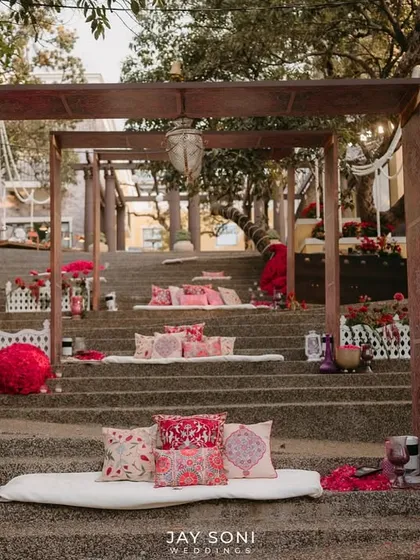 A straight-on shot of the tiered seating, highlighting the symmetry and the beautiful patterns of the cushions against the stone steps.