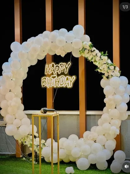 An elegant all-white balloon arch with accents of white flowers. This clean and classic look is perfect for sophisticated birthday celebrations.