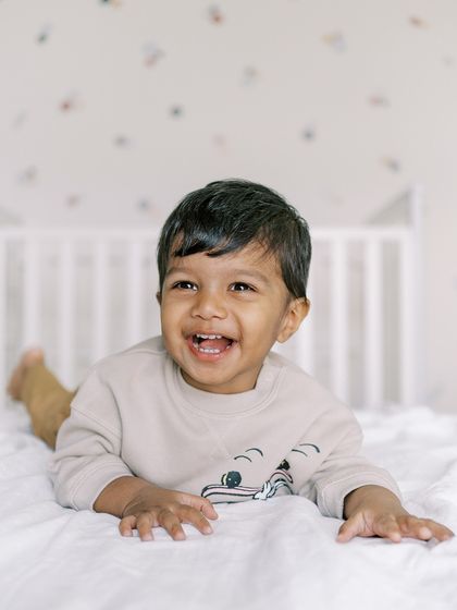 A little boy laughing on the bed. His happy, carefree spirit is perfectly captured in this shot.