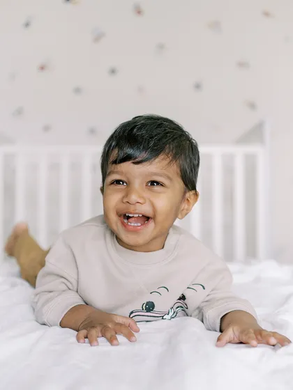 A big, happy laugh from a baby boy playing on the bed. These are the moments of pure, unscripted joy I love to capture.