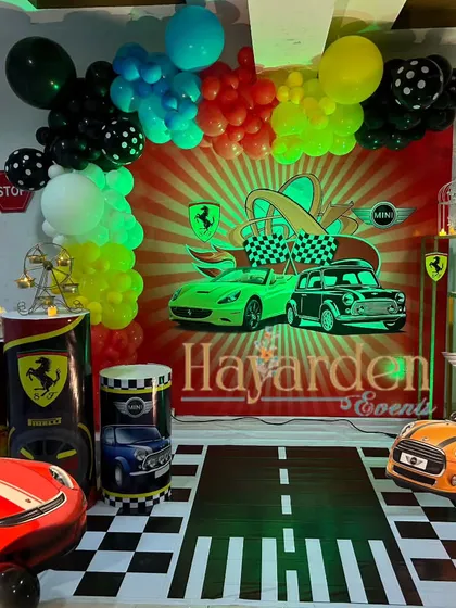 For the little car enthusiast, I designed this complete race car themed party. The setup includes a custom printed backdrop, themed plinths, car cutouts, and even a floor decal that looks like a road. It’s an immersive experience for a high-energy birthday.
