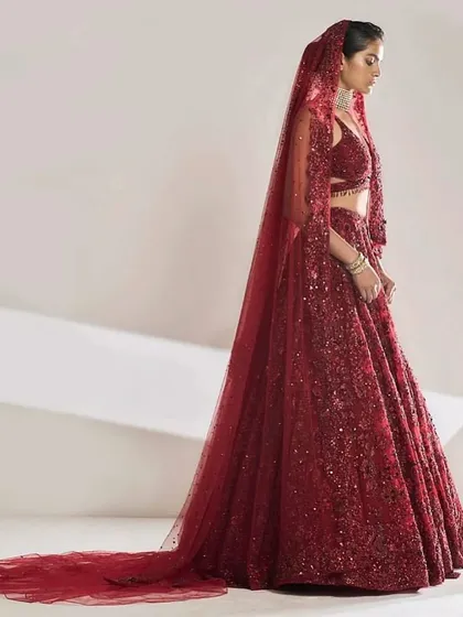 A breathtaking side profile of a full-sequined red bridal lehenga with a long, dramatic veil. My styling focused on creating a powerful silhouette that speaks of modern bridal grandeur and high-impact glamour.