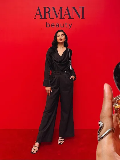A full-length shot of my outfit against the iconic red Armani Beauty backdrop, blending fashion with beauty.