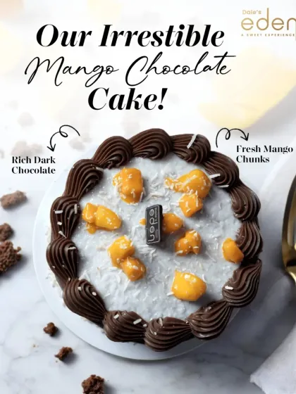 Our irresistible Mango Chocolate Cake. This overhead shot shows the beautiful contrast between the rich dark chocolate piping and the bright, fresh mango chunks, sprinkled with coconut.