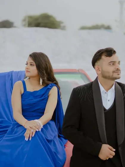 Using a car as a prop can add a cool, modern vibe to a pre-wedding shoot. Here, the couple's stylish outfits and the unique setting come together for a very chic photo.