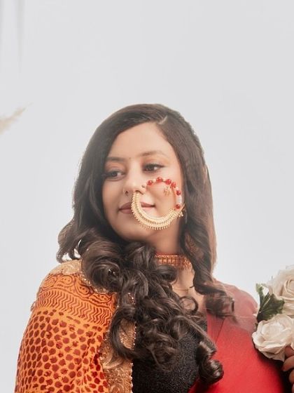 A close-up portrait focusing on the mom-to-be's beautiful smile and traditional jewelry, including a stunning nath (nose ring).