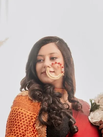 A close-up portrait focusing on the mom-to-be's beautiful smile and traditional jewelry, including a stunning nath (nose ring).