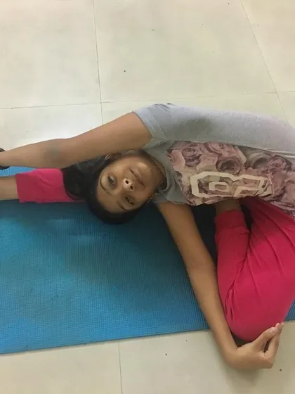 A young student in Parivrtta Janu Sirsasana (Revolved Head-to-Knee Pose). Twisting lengthens the spine and allows energy to flow more freely.