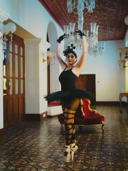 A ballerina poised in the historic halls of the Royal Opera House. These grand venues inspire us to elevate our art and dream bigger.