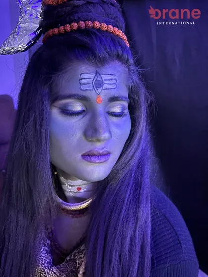 Another view of the Shiva look under blue light, demonstrating how makeup interacts with different lighting conditions.