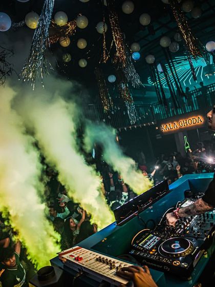 Surrounded by vibrant green smoke and intricate lighting at the Kala Ghoda club. I use colored smoke to match the theme and lighting of the event.