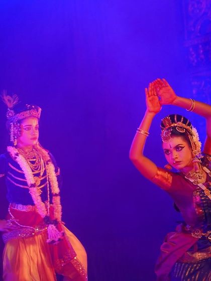 A dramatic pose between two dancers from "KRISHNA". The intense blue lighting and the performers' focused expressions create a powerful visual narrative.