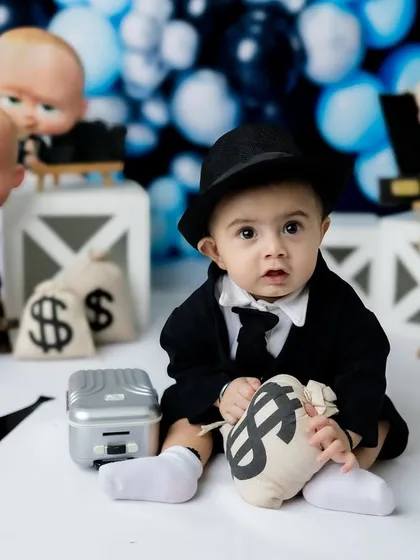 A curious look from this tiny executive, surrounded by his bags of money.
