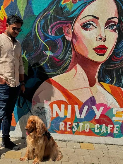 Posing against the vibrant wall art at Nivy's Resto Cafe.