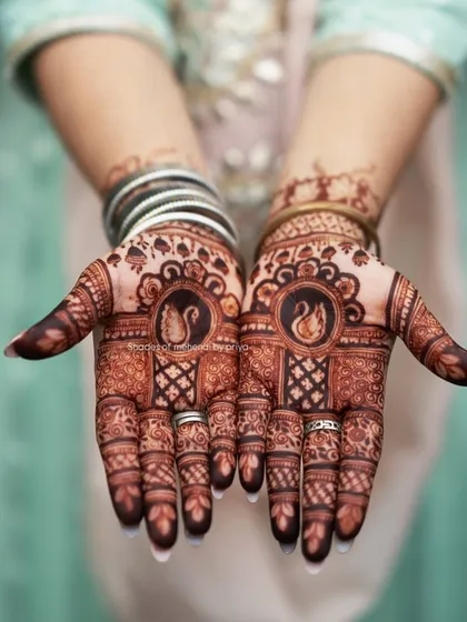The beautiful, rich stain of an engagement mehendi. This design features swans inside a circular frame, a symbol of love and grace.