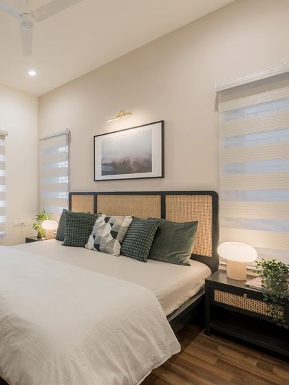 A wide shot of the master bedroom, emphasizing its spacious and airy feel, with large windows and a simple, elegant design.