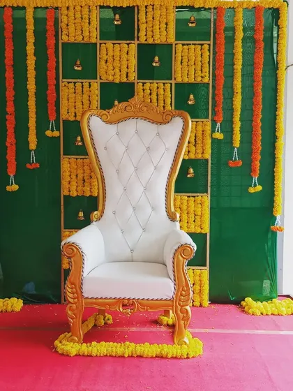 Here is a traditional Seemantha function setup. I used a classic high-back throne chair and created a backdrop with a green base and a grid pattern made from fresh yellow marigold flower garlands (chendu hoovu).