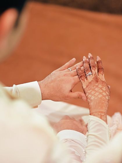 A close-up of the couple's hands, now adorned with their engagement rings, symbolizing their new commitment.