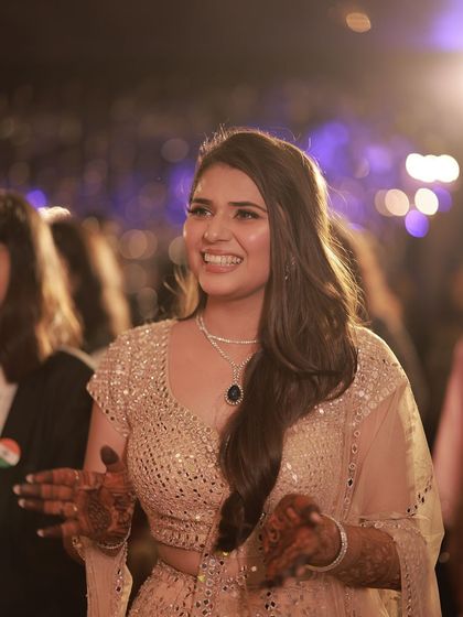 A candid shot of the bride enjoying her Sangeet, her hair looking effortlessly chic.