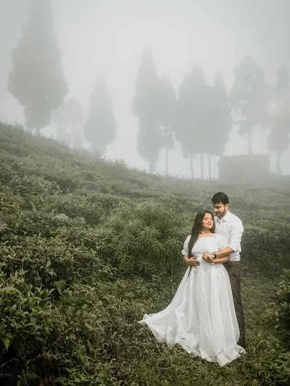 A moody and romantic portrait of a couple in a misty tea garden. The fog adds a layer of mystery and intimacy, making the moment feel private and magical.