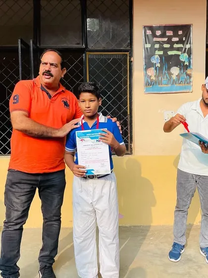 A proud moment for this student, his principal, and his coach. Celebrating his victory at the Open National Taekwondo Championship.