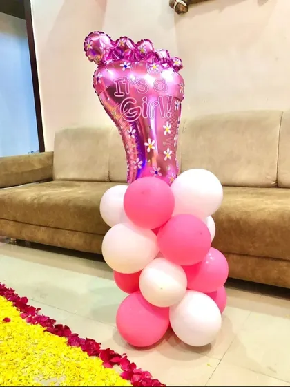 A close-up of an "It's a Girl!" balloon pillar. This element, combined with a flower petal carpet, adds a special touch to any welcome home celebration.