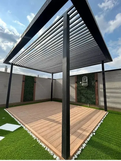 Here is the clean, structural base for a terrace transformation. We've installed a modern black pergola over a composite wood deck, with artificial turf and accent green wall panels ready for furniture and final touches.