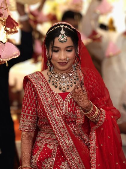 A bride enjoying her wedding ceremony in a stunning red lehenga. My outfits are designed to be comfortable for long hours of celebration.