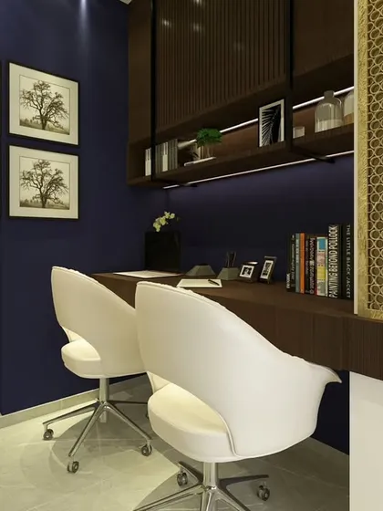A close-up of the dual workstation, showcasing the clean lines and the warm glow of the under-shelf lighting. Framed art and a touch of greenery complete the look.