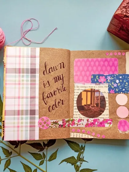 A flatlay of a finished art journal page with a pink and brown color scheme, showcasing how to style your artwork for photos.