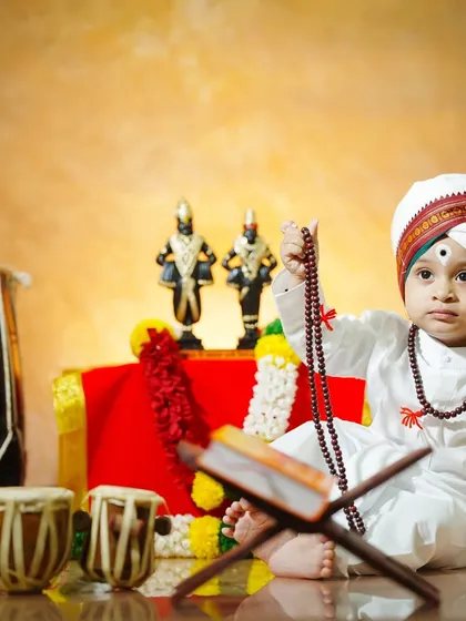 Holding a string of prayer beads, this little Varkari looks on with pure innocence in our traditional Ashadi Ekadashi setup.