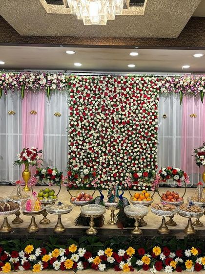A simple yet beautiful stage with a red and white flower wall.