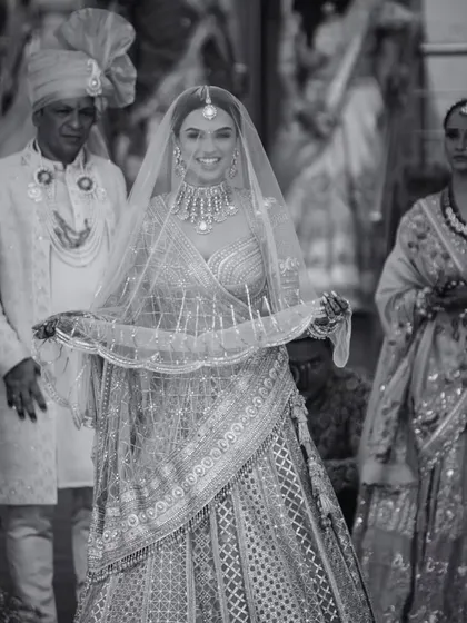 A classic black and white portrait of the bride, Aayushi, on her wedding day. Her radiant smile and elegant attire capture the timeless beauty of the moment.