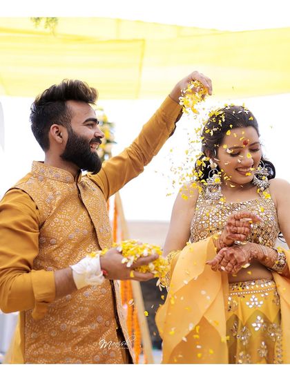 A playful moment where the groom showers the bride with flower petals, their laughter making the shot extra special.