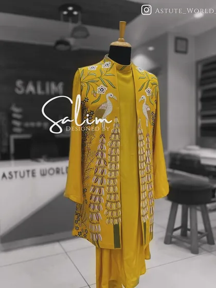 A yellow Indo-Western jacket on a mannequin, featuring beautiful bird and floral embroidery. This piece shows how I incorporate elements of nature into my designs.