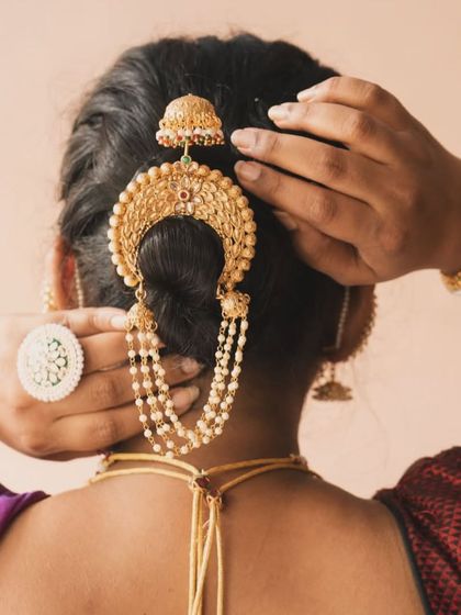 A beautiful shot from the back, showcasing how to style a traditional Maharashtrian bun with our intricate khopa hair accessory. The matching pearl bangles complete the look.