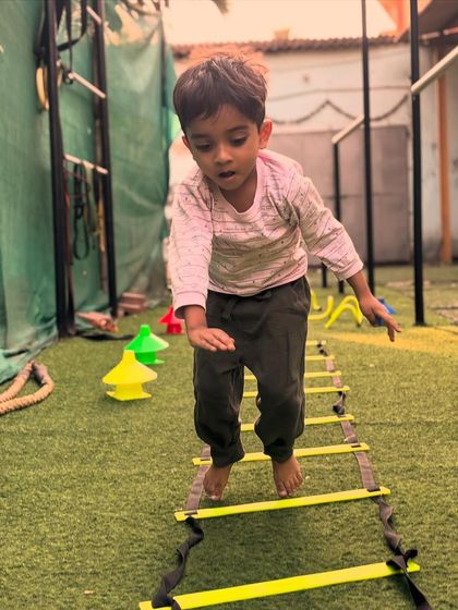 Quick feet, sharp mind. This little one is focused as he moves through the agility ladder, a fun drill that enhances coordination and speed.