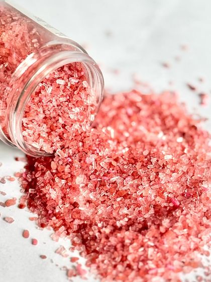 A close-up of the texture of our Rose-Tic Charm bath salts. You can see the different salt crystals and the fine rose petal powder mixed in.