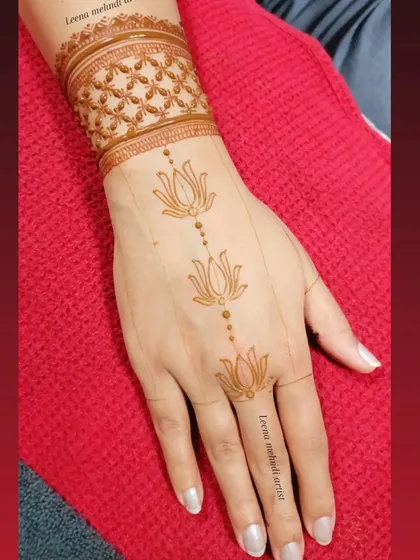 A minimalist take on the lotus design, with a single line of flowers. This is a great example of an elegant and modern henna style that is quick to apply.