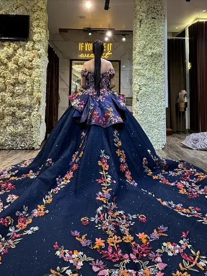The back view of our navy floral ball gown is just as stunning as the front. The colorful embroidery continues down the entire length of the magnificent train, ensuring a breathtaking exit.